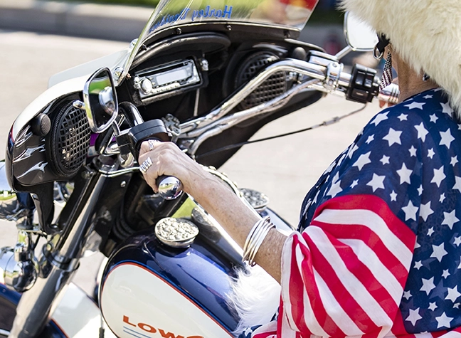 Image of woman wrapped in American flag on motorcycle