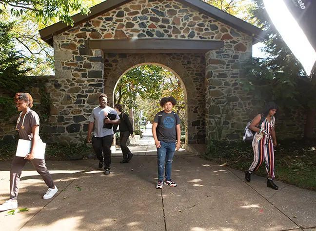 A group of students walking through a brick entry way on the CCBC Catonsville campus.