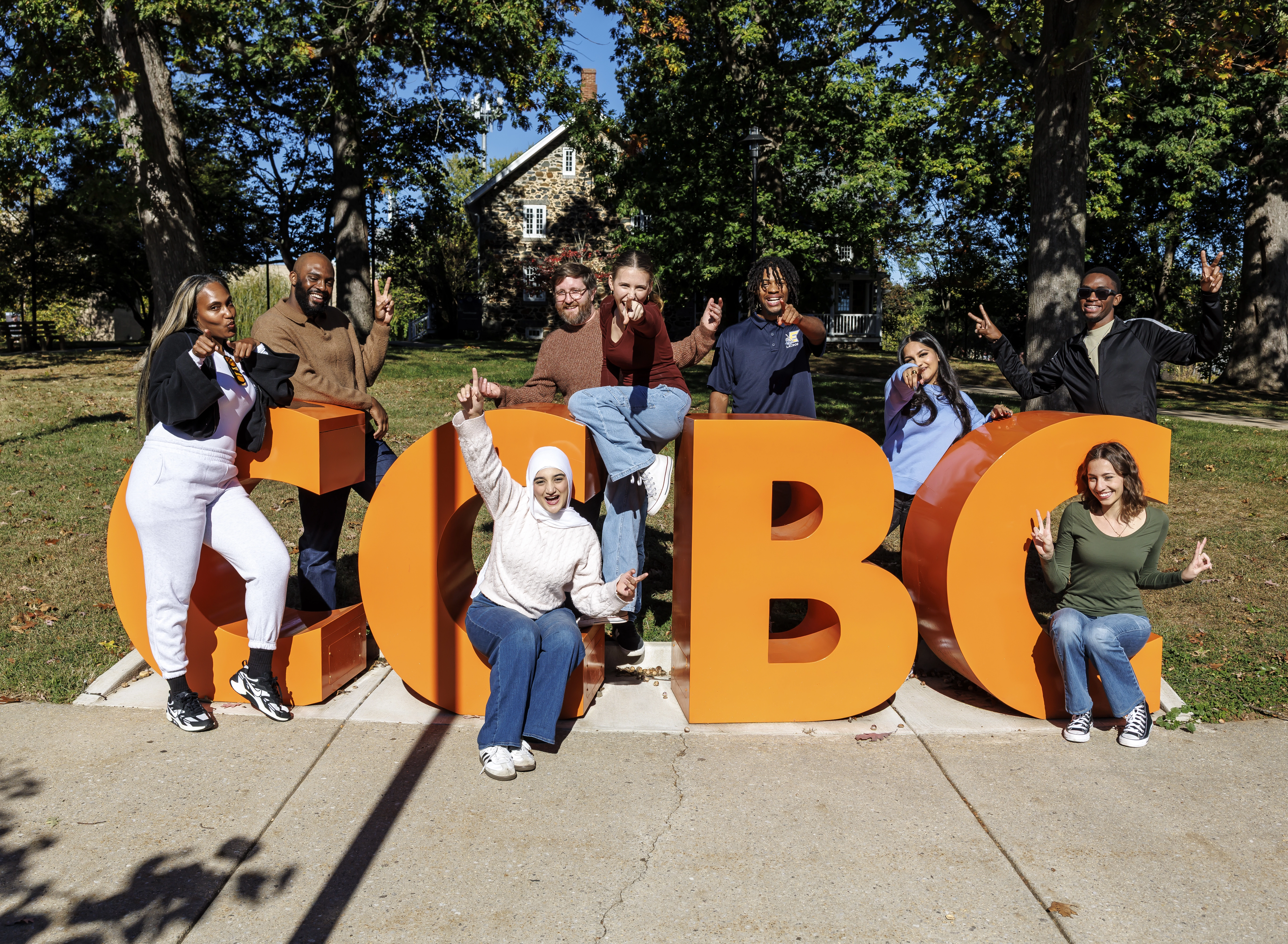 CCBC's 2025-26 Fresh Faces huddled around CCBC's trademark big, orange letters.