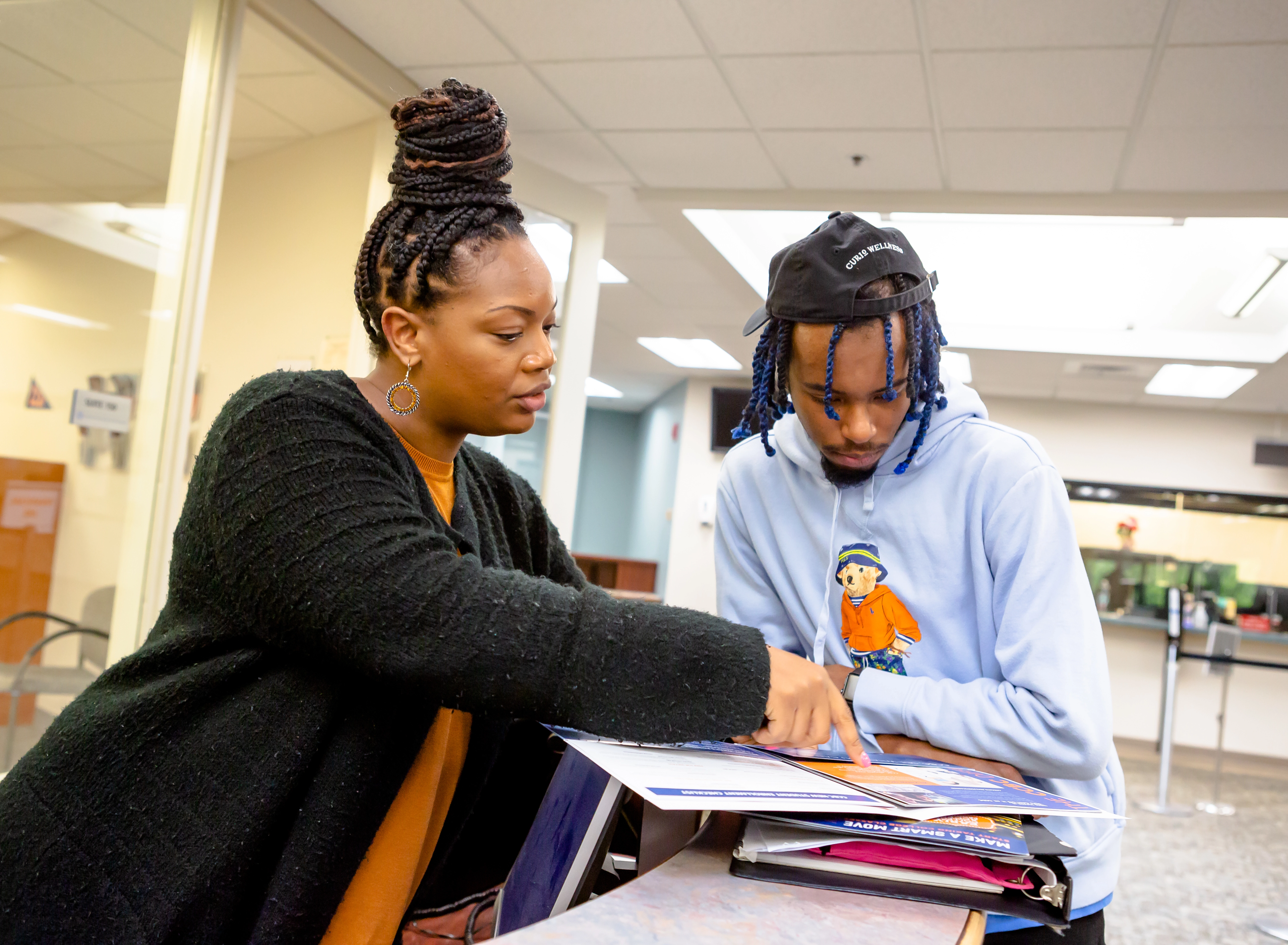 An advisor helping a student understand the contents of an admissions packet.