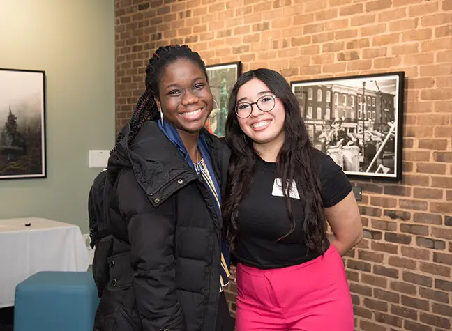 Two students smiling.