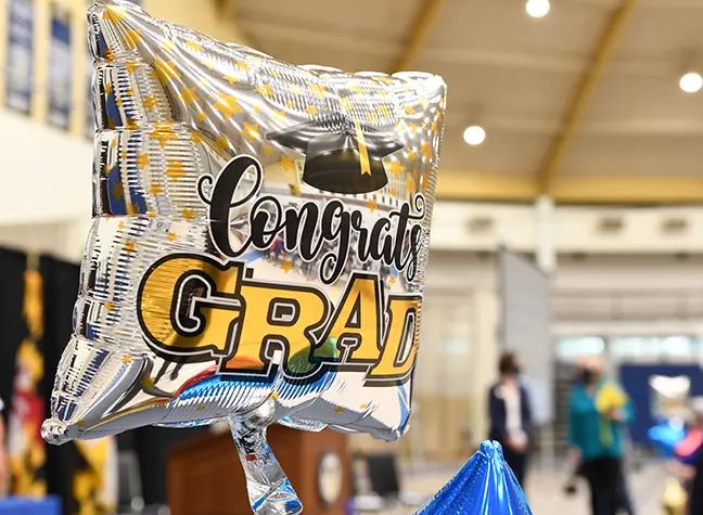 A silver balloon reads "Congrats Grads!"