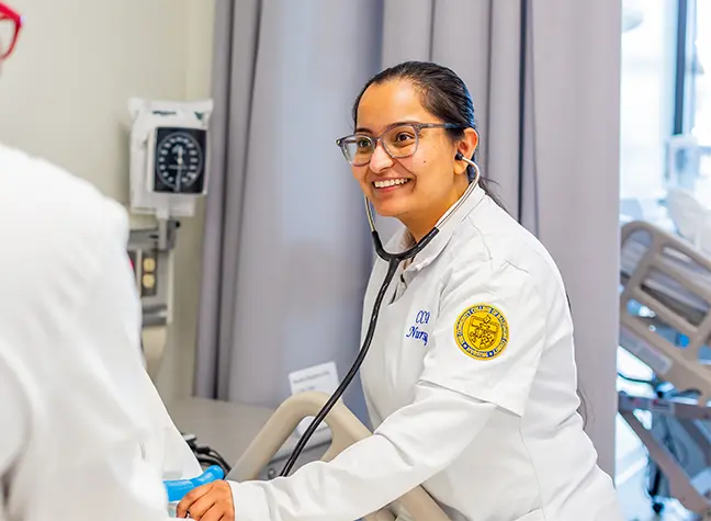 Female nursing student helping patient