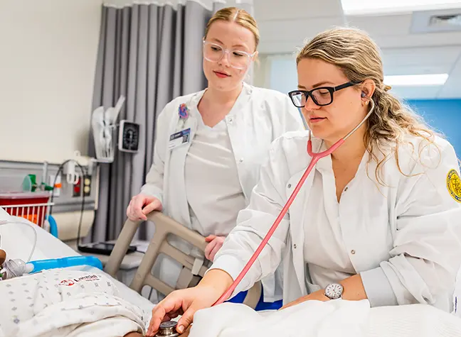 Female nursing student helping patient