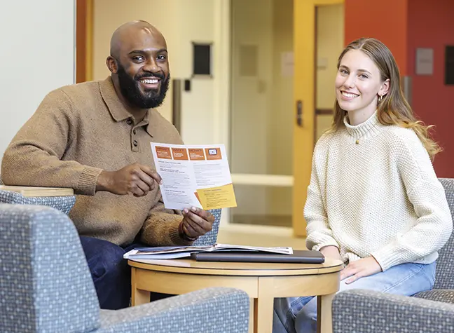 Two students sitting together in lobby