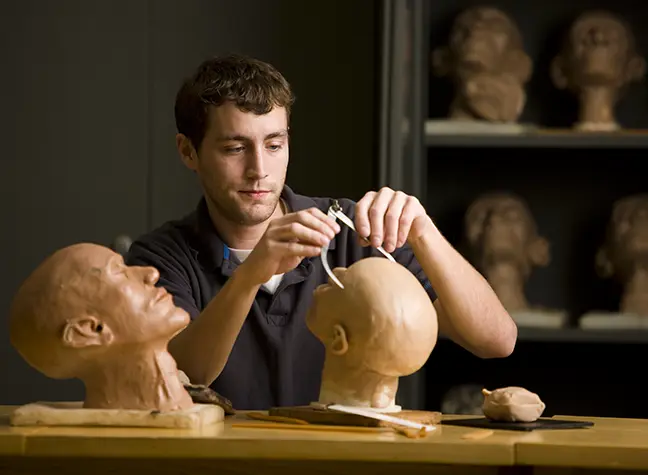 Photo of student working in mortuary classroom