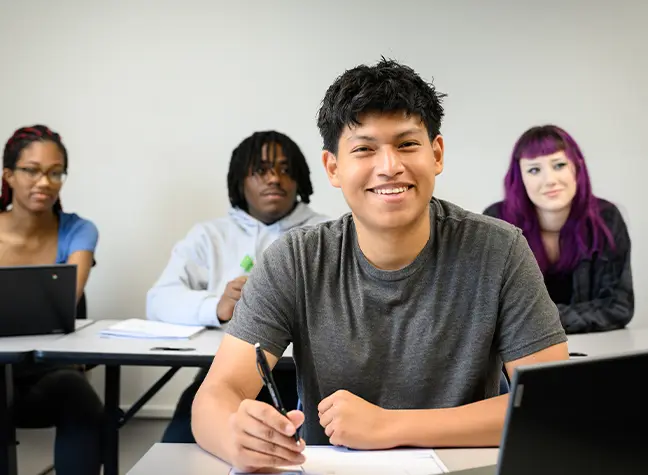 ECAP student in classroom posing while working on school work