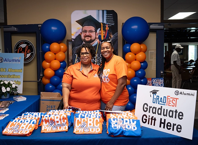 Two CCBC employees at a grad fest table.