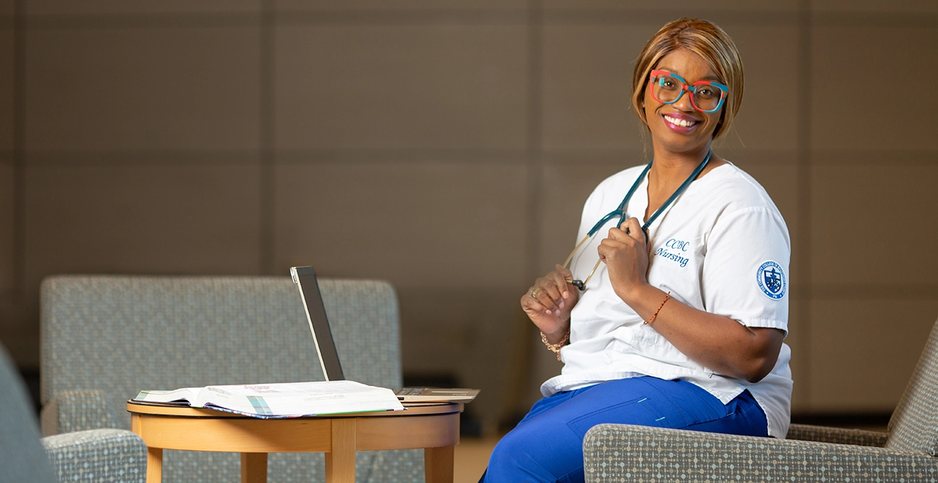 Nursing student sitting in chair with laptop