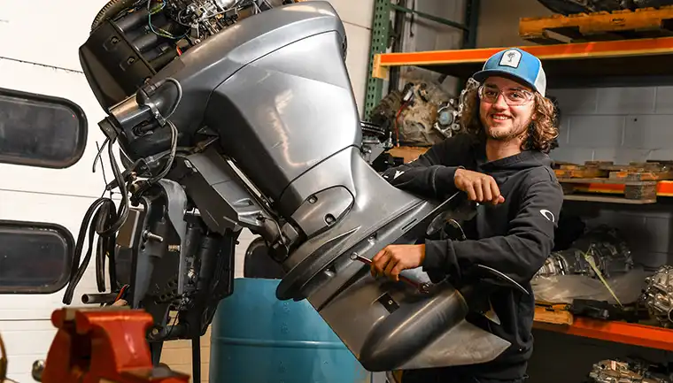 Student working on a boat motor