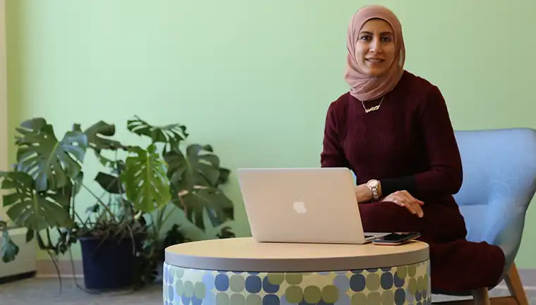 women sitting in a lobby with her laptop