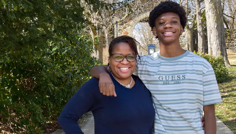 Mother and son smile for a photo on a bright and sunny day.