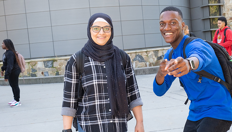 Two students posing for a photo outside on campus