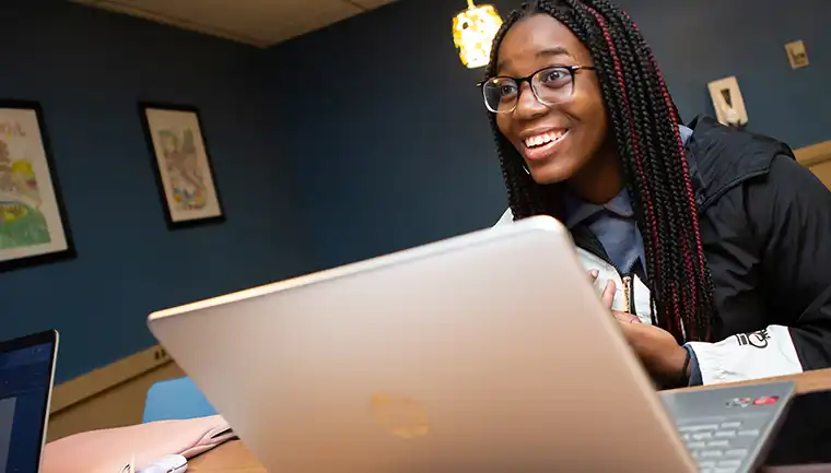 Student studying in lobby on laptop