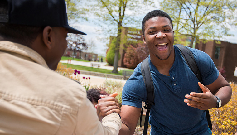 Excited student shakes hands with friend