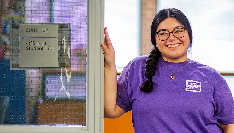 Student standing by the Office of Student Life office