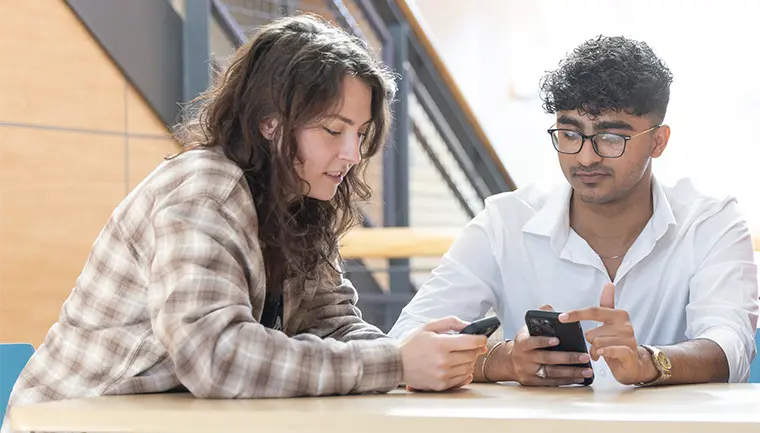 Two students looking at their phones
