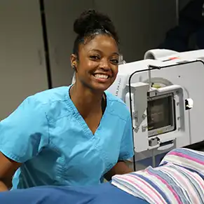 Student in in front of x-ray machine.