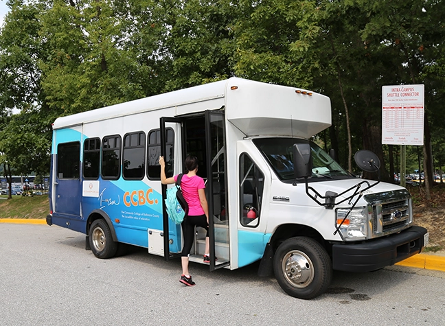 Woman getting into shuttle bus.