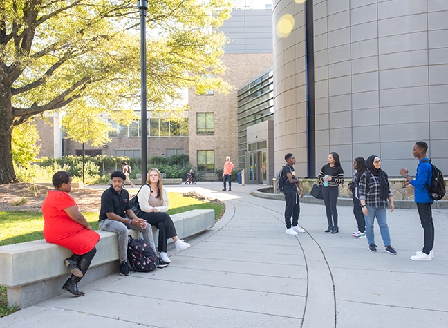 Students enjoying a sunny day in front of the MASH building