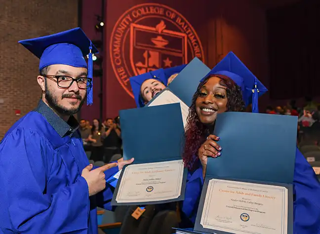 GED graduates holding up their diplomas