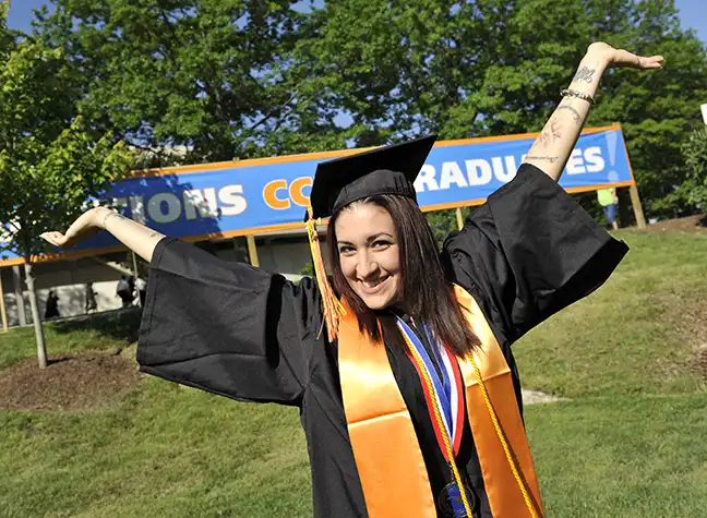 Graduate with her arms up in excitement