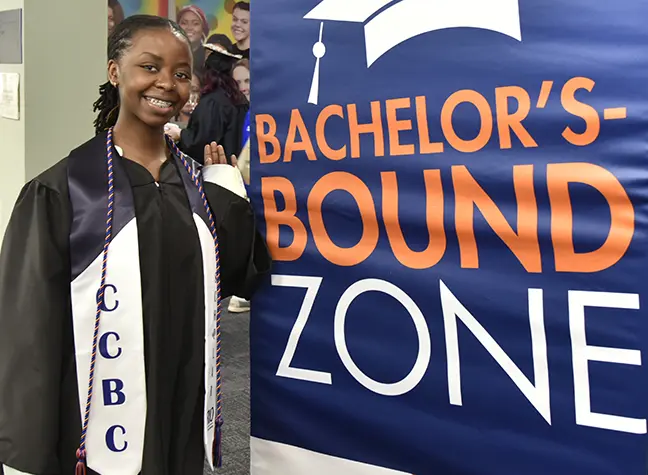CCBC graduate standing in front of a sign that reads Bachelors Bound