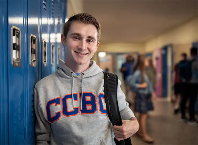 High school student standing in hallway wearing a CCBC hoodie
