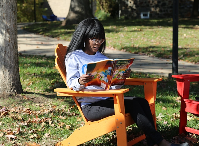 Girl reading textbook outside