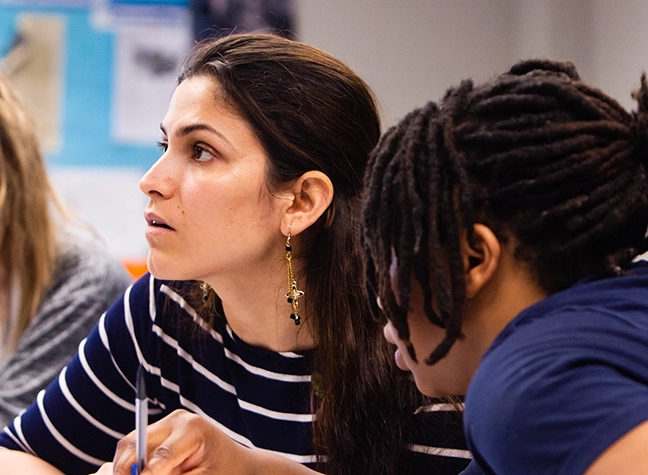 Group of female students writing together.