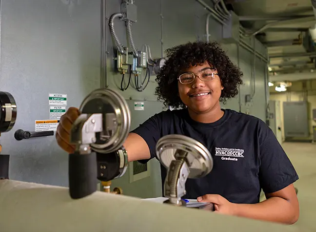 Male HVAC student using equipment