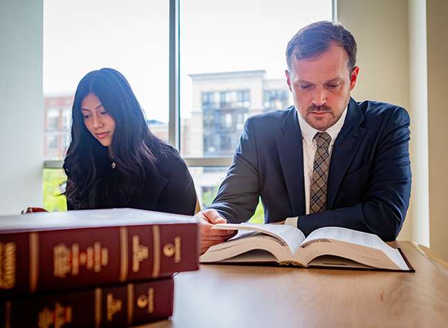 Male student and female teacher approach judges bench