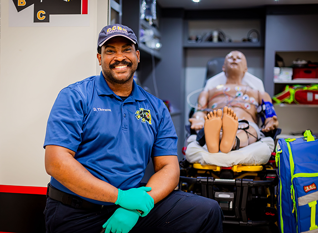 CCBC EMT Faculty standing in front of training ambulance
