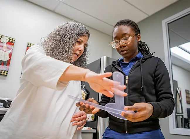 Health Professions Student looking into a microscope
