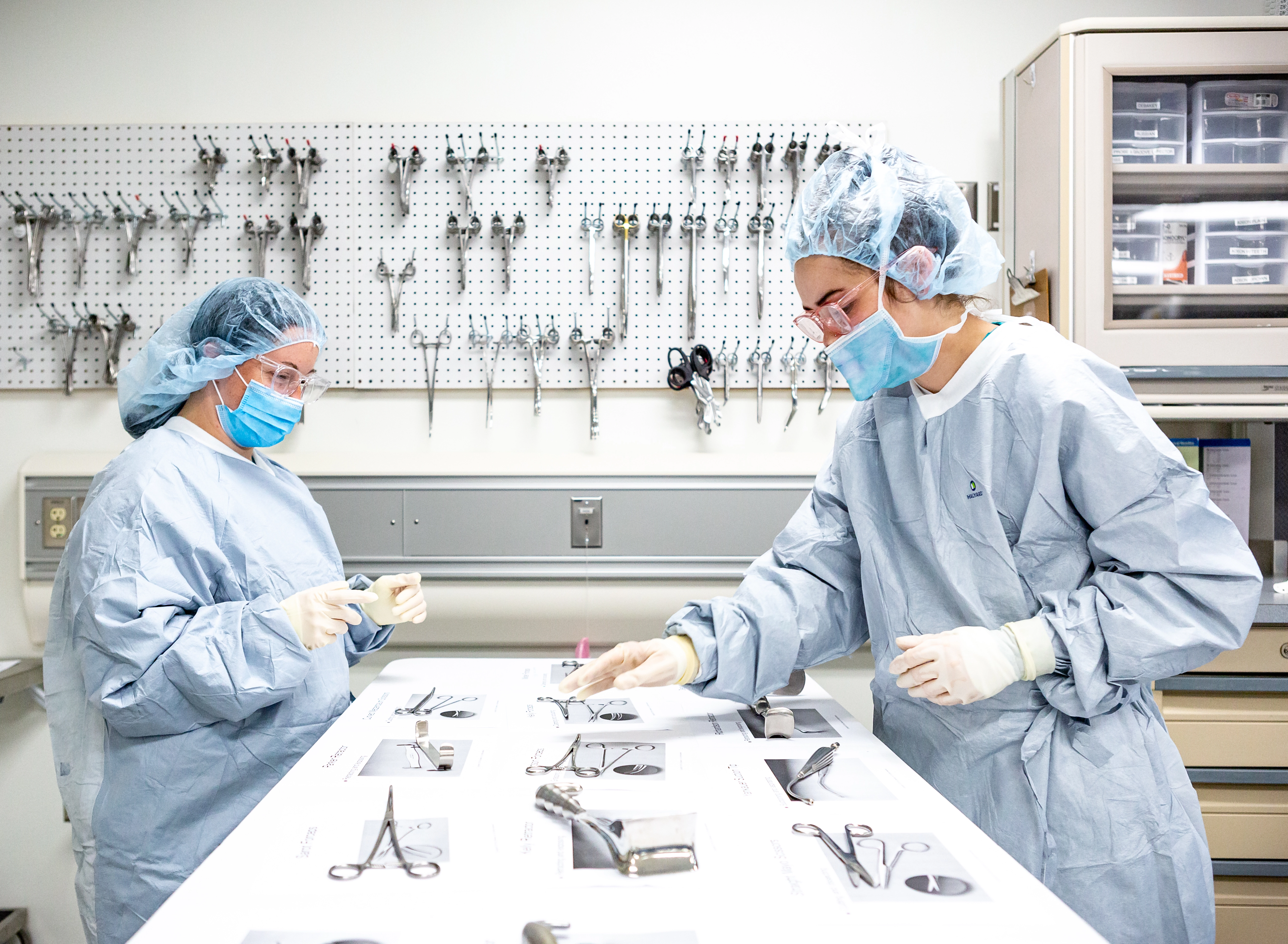 Two surgical technology students learning to identify and prepare surgical tools.