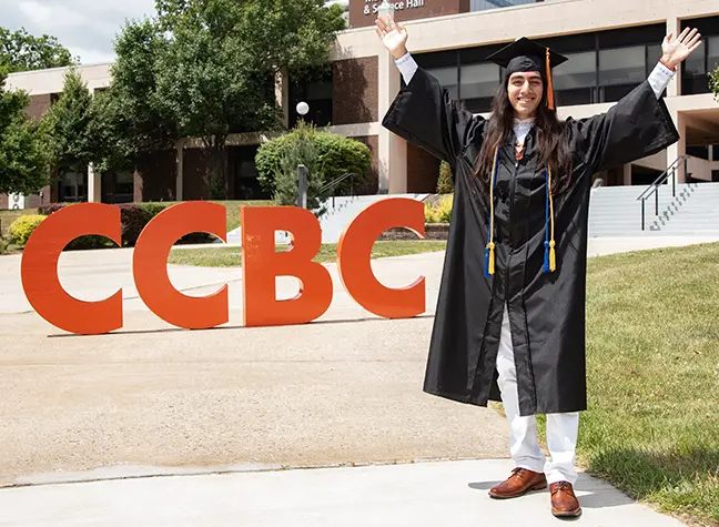 Graduate holding CCBC sign