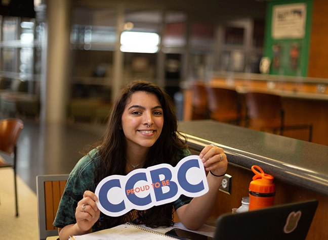 Graduate holding CCBC sign
