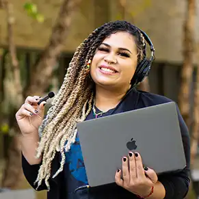 Close up of Victoria holding a laptop and microphone