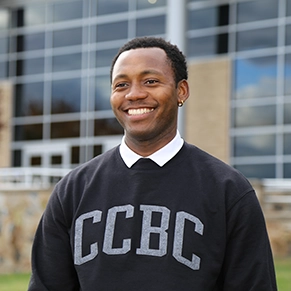 Close up of Bernard smiling wearing CCBC shirt