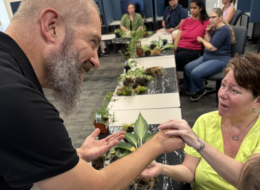 Man assisting deafblind woman in a classroom