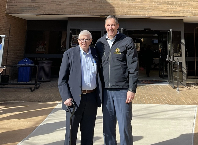 Photo of two men in front of building