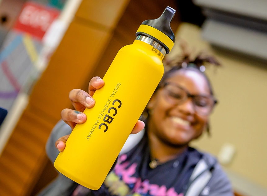 Student holding up a yellow CCBC water bottle